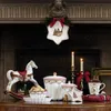 A festive Christmas display on a mantelpiece, featuring a rocking horse, decorative dishes, and candles. Produktbild-Vorschau