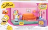 The image shows the packaging of a Simpsons Living Room Diorama playset, featuring Homer Simpson and the iconic living room. Podgląd zdjęcia produktu