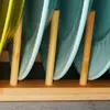 A close-up view of a bamboo dish rack holding several plates. Produktbild-Vorschau