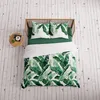 A top-down view of a bed with green bedding and a duvet cover featuring a banana leaf pattern. Podgląd zdjęcia produktu