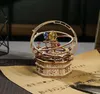 A wooden 3D puzzle of a celestial model sits on a sheet of music. Voir les images du produit
