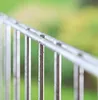 A close-up of a metal railing with a blurred green background. Podgląd zdjęcia produktu