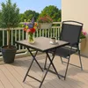 A patio set with a small table, a chair, and flowers on a balcony. Anteprima dell’immagine prodotto