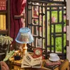 A miniature study scene with books, a lamp, a clock, and a teacup. Náhled obrázku produktu