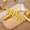 A hand is holding a spiral potato cutter with sliced potatoes on a skewer, placed on a wooden cutting board. Náhled obrázku produktu