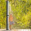 A young boy is showering outdoors next to a solar shower unit. Náhľad obrázku produktu