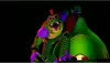 A large, animatronic alligator character with a red mohawk and star-shaped sunglasses is depicted in a dynamic pose, seemingly on a stage or platform. The background is dark, with a large green structure behind the character. Náhled obrázku produktu