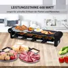 A raclette grill with food items arranged around it on a wooden table. Produktbild-Vorschau