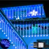 Blue icicle lights are displayed on the roof edge of a house, with a white star decoration in the background. Produktbild-Vorschau