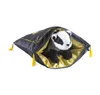 A plush badger toy peeking out of a dark grey pouch with gold lining and yellow tassels. Produktbild-Vorschau