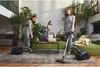 A woman is vacuuming a living room with a dog lying on the sofa. Náhled obrázku produktu