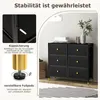 A black fabric dresser with six drawers and gold accents is shown in a room setting, with informational callouts about its stability features. Produktbild-Vorschau