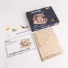 A flat lay of a wooden model kit, including the box, instructions, and unassembled parts. Podgląd zdjęcia produktu
