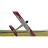 A remote-controlled airplane is shown in a field with hay bales in the background. Produktbild-Vorschau