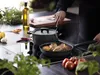 A person is cooking in a kitchen, with a pot and pan on a stovetop. Podgląd zdjęcia produktu