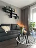 A living room scene with a sofa, coffee table, and decor. Produktbild-Vorschau