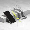 A smartphone screen protector and installation guide are displayed on a concrete surface. Produktbild-Vorschau