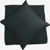 A dark pillowcase is folded and placed on top of another pillowcase, both on a white background. Produktbild-Vorschau