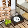 A vintage-style Bluetooth speaker with a CD player, placed on a wooden surface with some greenery. Produktbild-Vorschau