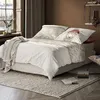 A cozy bedroom scene with a bed dressed in bedding featuring a sheep print. Produktbild-Vorschau