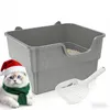A cat wearing a Santa hat and scarf is in the foreground, with a gray litter box and a white litter scoop in the background. Produktbild-Vorschau
