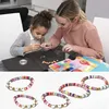 A woman and a child are making jewelry, with finished bracelets shown below. Produktbild-Vorschau
