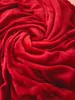 A close-up, swirling texture of a red blanket. Produktbild-Vorschau