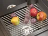 Fruits being washed in a sink on a drying rack. Podgląd zdjęcia produktu