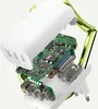 A cutaway view of a white Belkin BoostCharge power adapter, revealing its internal circuitry and components, with a green shield-like frame around it. Produktbild-Vorschau