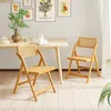 A dining room setting with a wooden table and two folding chairs. Podgląd zdjęcia produktu