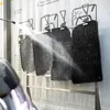 Car floor mats being washed with a pressure washer. Produktbild-Vorschau