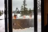 People relaxing in a hot tub outdoors in the snow. Produktbild-Vorschau
