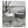 Two folded mattresses are placed on the ground near a body of water with trees and reeds in the background. Produktbild-Vorschau