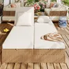 A rattan garden sofa with white cushions and adjustable backrests is set up on a wooden deck, surrounded by plants and flowers. Anteprima dell’immagine prodotto