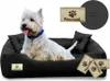 A white West Highland Terrier dog is lying in a black dog bed. There are also some tags and a circular swatch of fabric shown. Produktbild-Vorschau