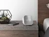 A digital alarm clock and a smartphone charging on a nightstand next to a bed. Podgląd zdjęcia produktu