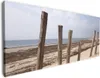 Wallario Premium Leinwandbild Sandstrand mit Holzpfählen am Produktbild-Vorschau 1