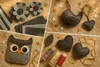 A collage of felt crafts including flowers, an owl, a bird, hearts, and spools of thread, arranged on a textured brown background with small star cutouts. Náhled obrázku produktu
