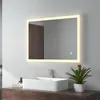 A modern bathroom vanity with a rectangular sink, a faucet, and a large illuminated mirror above it. A small potted plant sits on the counter to the right of the sink. Produktbild-Vorschau
