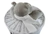 A plush toy hippo wearing a scarf is placed on top of a white wicker laundry basket. Produktbild-Vorschau