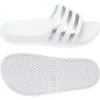 A top-down view of a pair of white Adidas Adilette Aqua slippers with silver stripes, shown from the top and the sole. Produktbild-Vorschau
