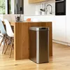 A modern kitchen with a wooden island and a stainless steel trash can. Anteprima dell’immagine prodotto