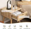 A close-up of a wooden nightstand with an open drawer, showcasing its features and storage space. The background is a bedroom setting. Náhled obrázku produktu