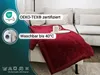 A red blanket draped over a sofa with a mug on it. Produktbild-Vorschau
