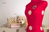 A red sewing mannequin is displayed on a table with sewing supplies. Produktbild-Vorschau