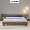 A bedroom scene featuring a bed with two mattresses, pillows, and nightstands. Náhľad obrázku produktu