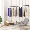 A room with a wall-mounted clothing rack, a chair, and storage baskets. Produktbild-Vorschau