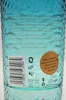 Close-up of the back of a blue glass bottle with text and a barcode. Náhľad obrázku produktu