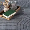 A close-up shot of a rug with a book, vase, and candle on a wooden tray. Anteprima dell’immagine prodotto