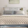 A bedroom scene featuring a white headboard with shelves above a bed with pillows and a quilted blanket. Náhľad obrázku produktu